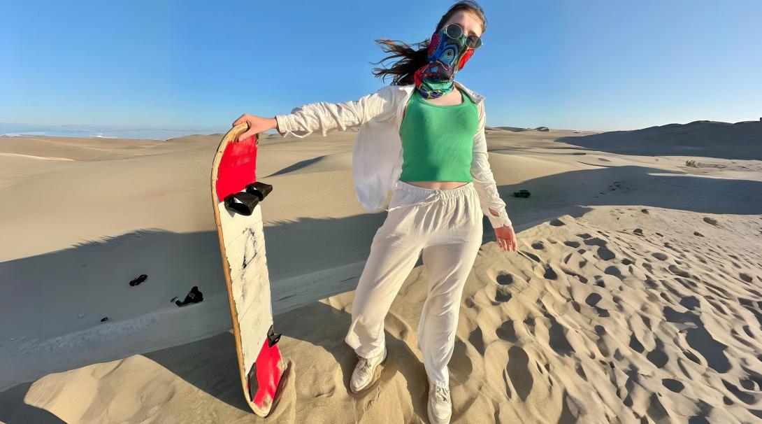 Sandboarding down golden dunes in Peru